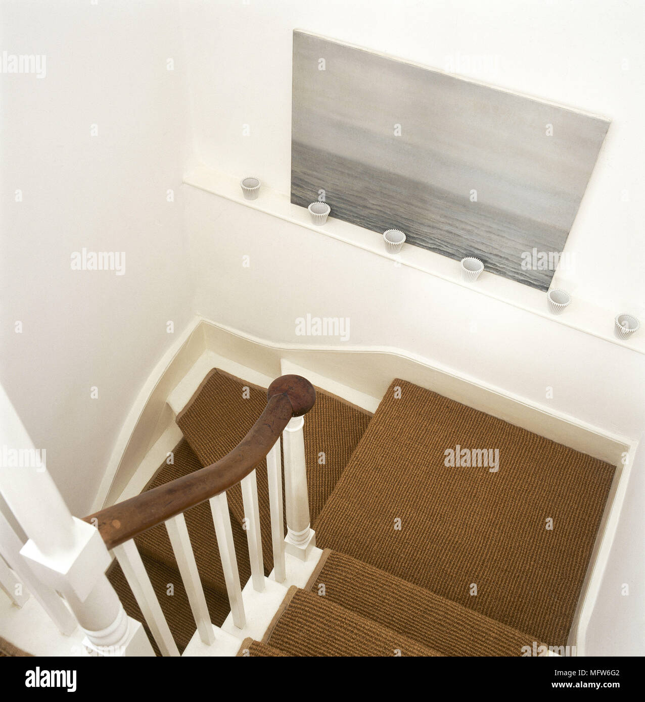 Above view of a carpeted staircase with wooden banister Stock Photo