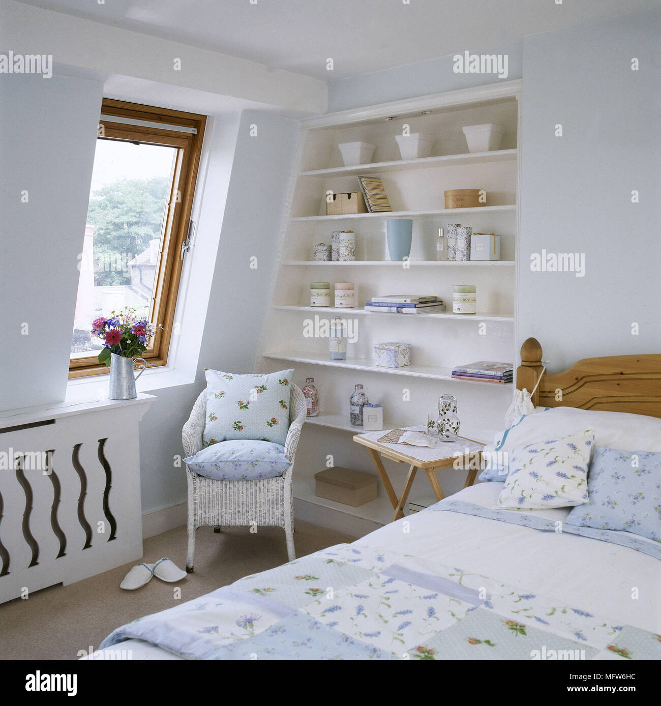 Double Bed And Lloyd Loom Wicker Armchair With Floral Cushions In Blue Country Style Bedroom Stock Photo Alamy