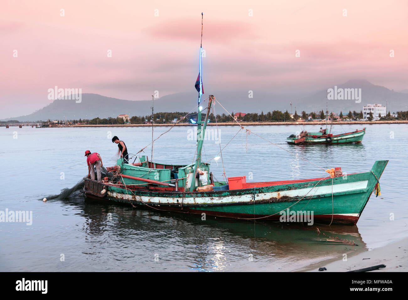 Fishing boats on the Preaek Tuek Chhu river in Kampot town Stock Photo