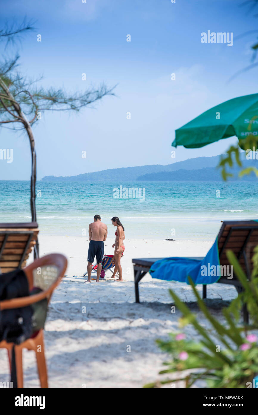 Candid shot of a young couple talking on a white sand beach on an island in Southeast Asia Stock Photo