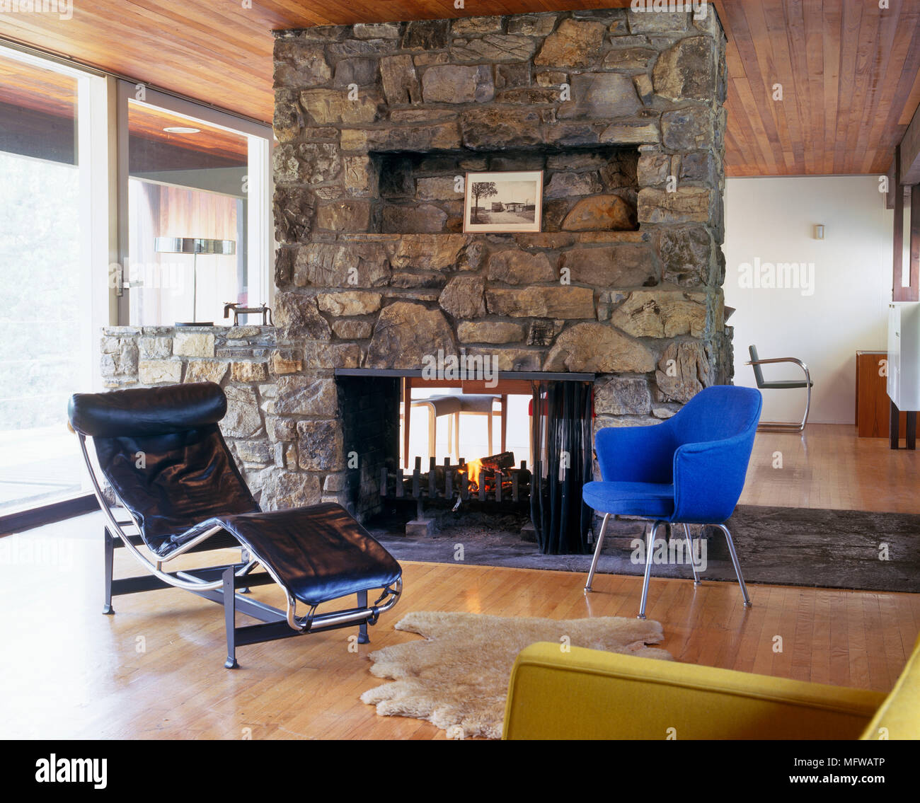 Le Corbusier Black Leather Recliner In Front Of Stone Fireplace In