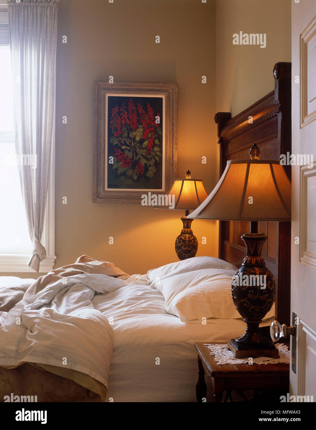 Lit Lamps On Bedside Tables Either Side Of Double Bed In