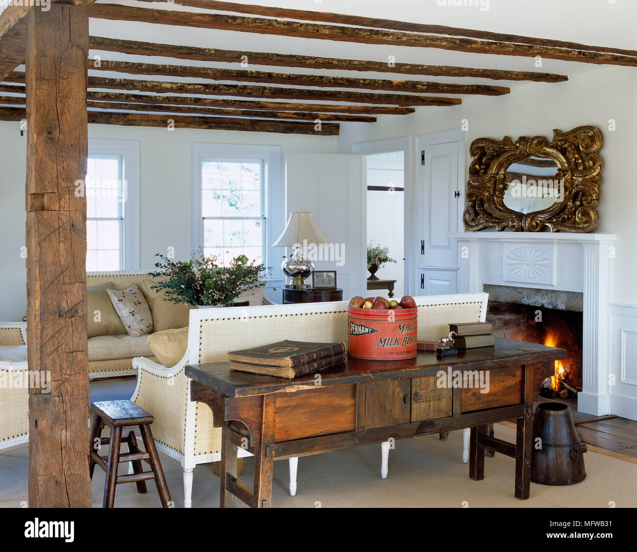 Pair of sofas facing each other in front of fireplace with lit fire in