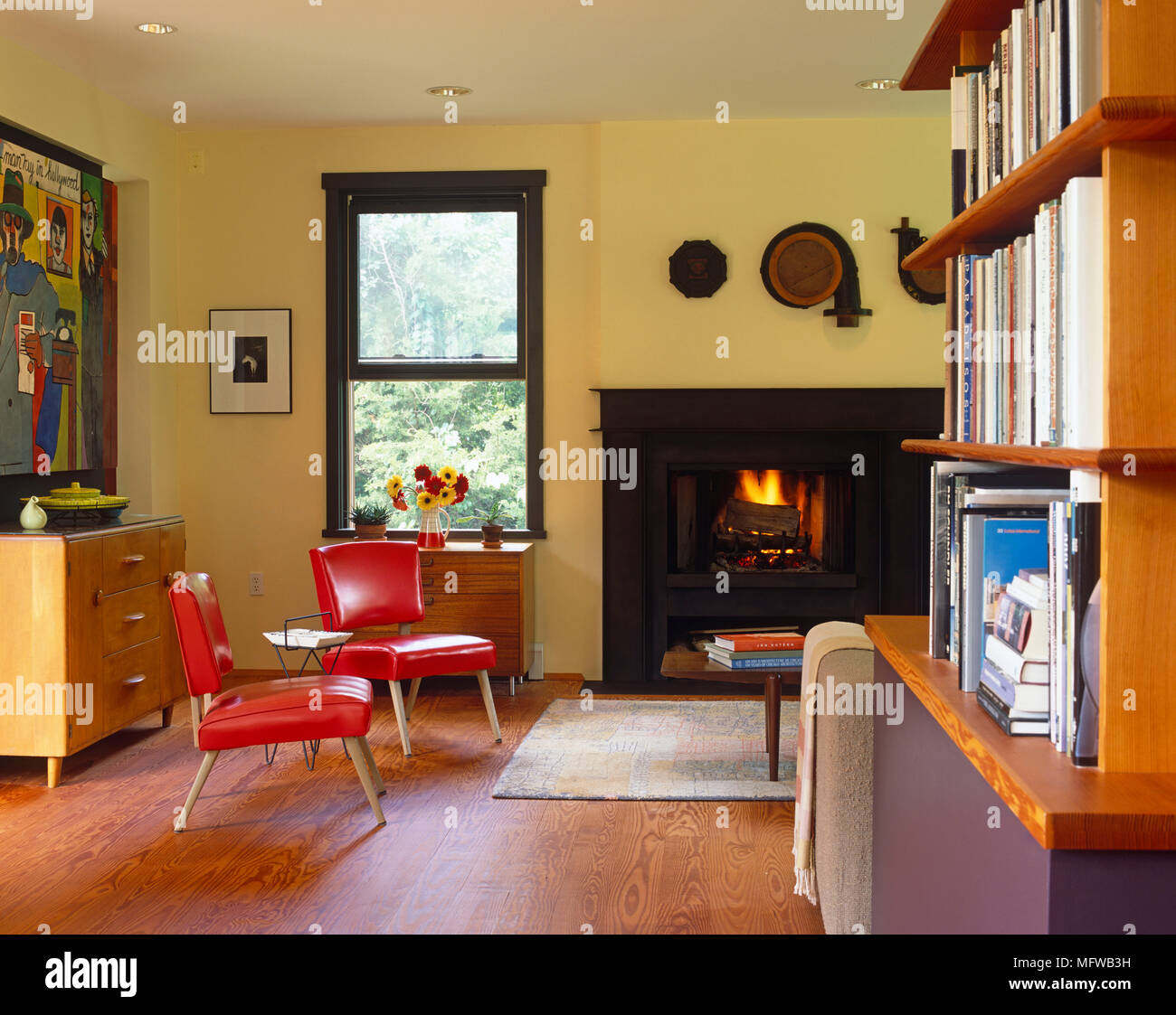 Pair of upholstered red leather armchairs in front of fireplace with