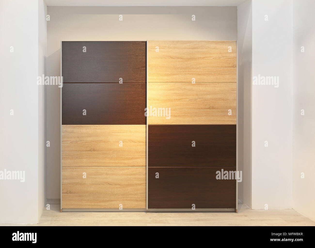 Big Wardrobe Closet With Wooden Doors in Bedroom Stock Photo
