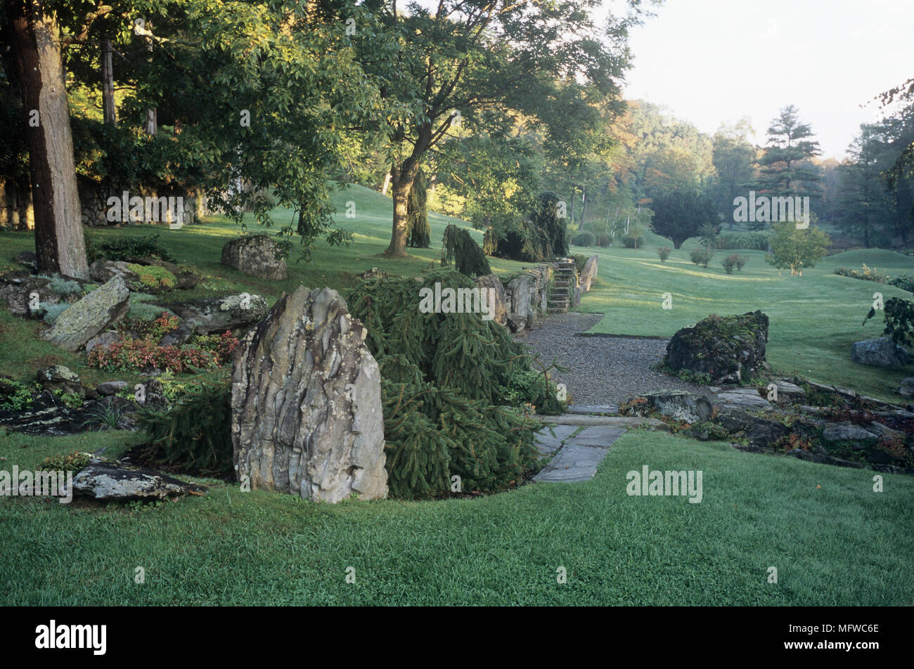 Rockery and trees in a lawned garden Stock Photo - Alamy