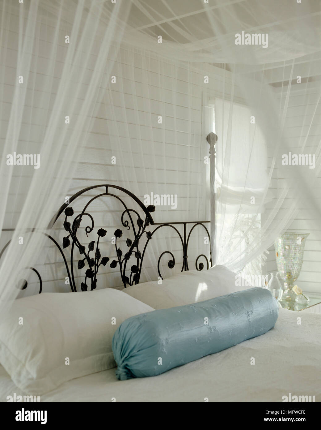 Wrought iron double bed in country style room with white sheer bed canopy Stock Photo Alamy