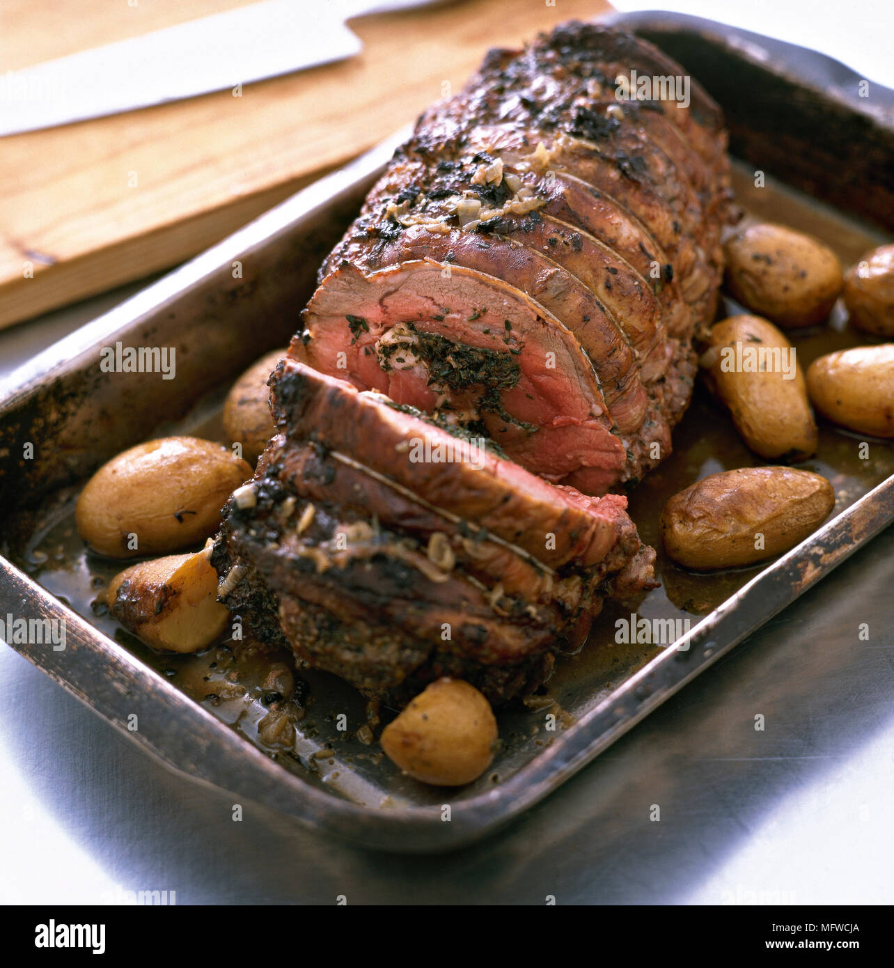 Roast beef joint and roast potatoes in roasting tin Stock Photo Alamy