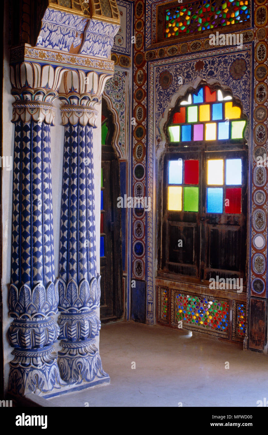 Richly decorated blue hallway with pillars and stained glass window Stock Photo