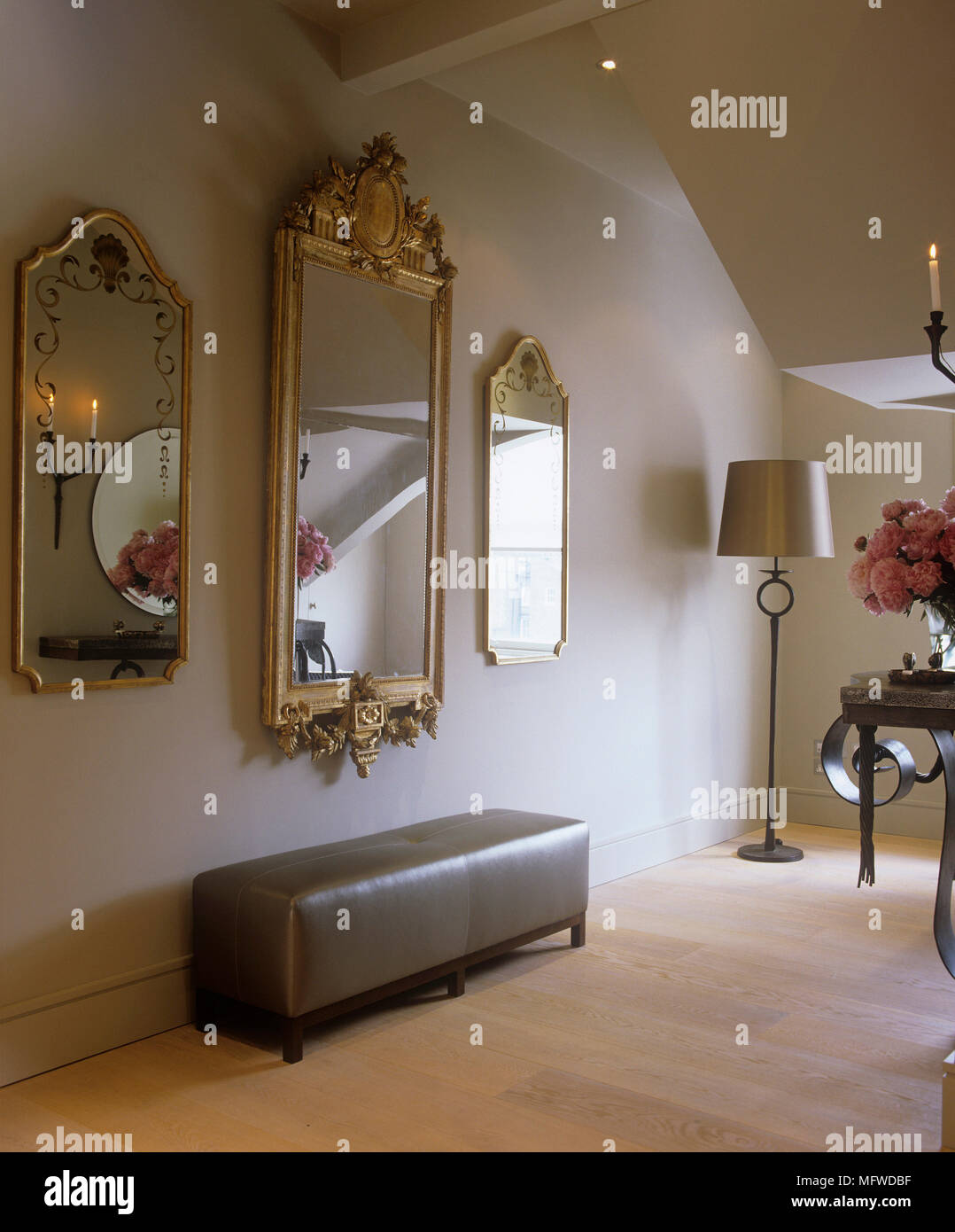 Hallway With Framed Mirror Above Upholstered Bench Stock Photo