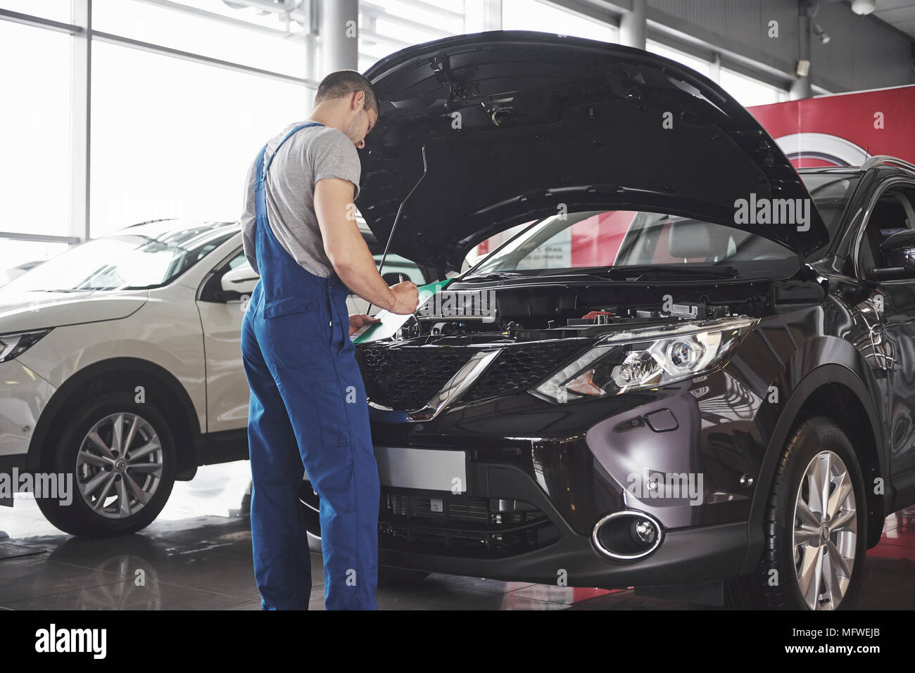 Portrait of a mechanic at work in his garage - car service, repair ...