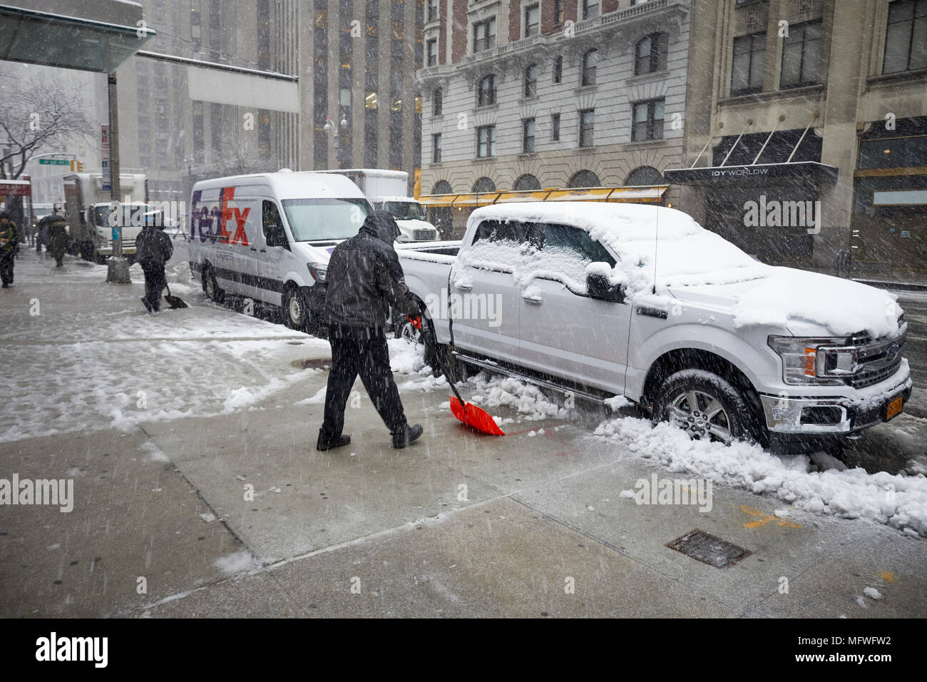 Manhattan in New York City , office worker clearing snow from the sidewalk  Broadway near Times Square Stock Photo