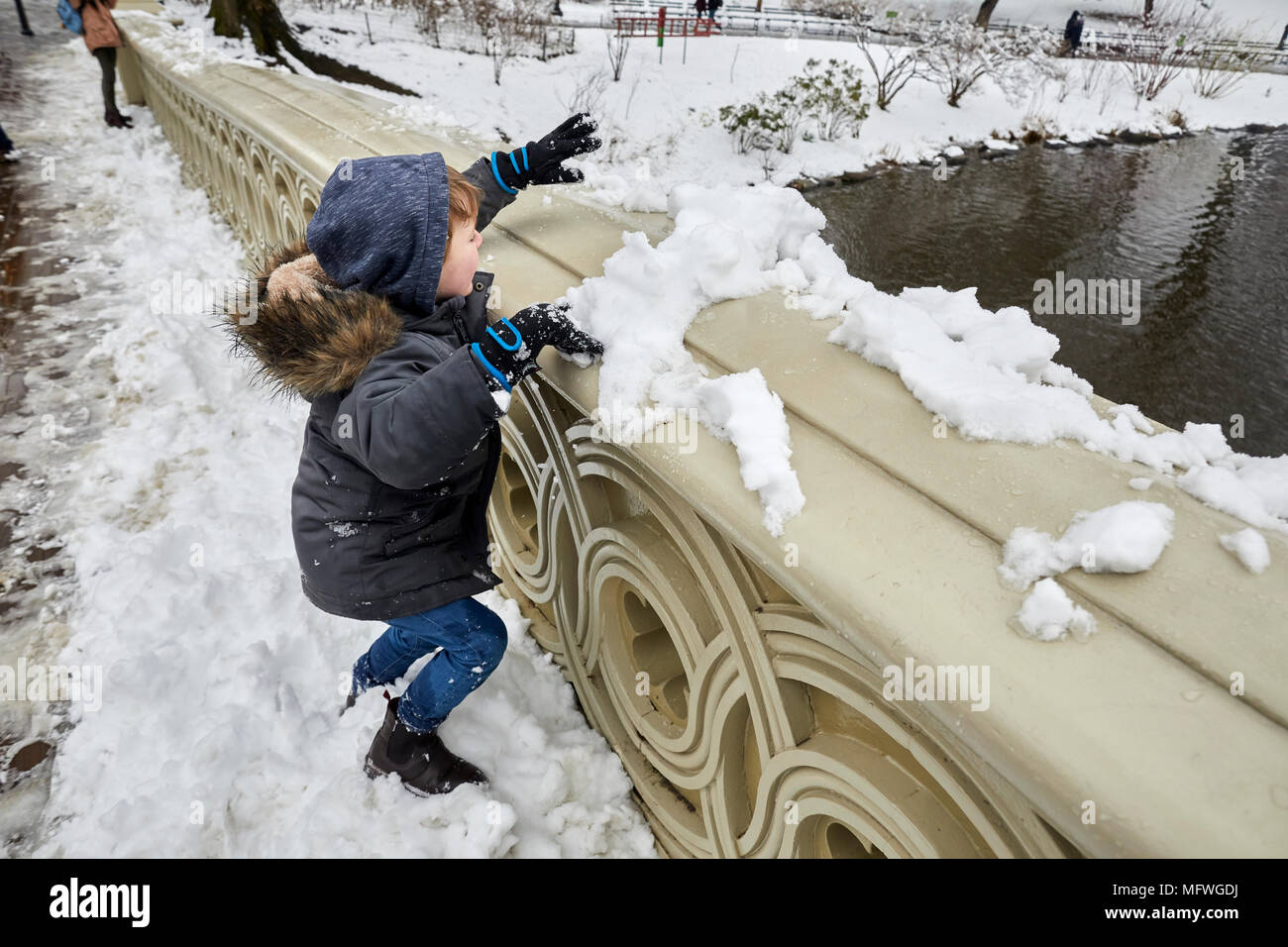 Manhattan in New York City  Easter snow covers Grand Central Park, 1862 pedestrian BOW bridge with a decorative banister is a well-known romantic spot Stock Photo