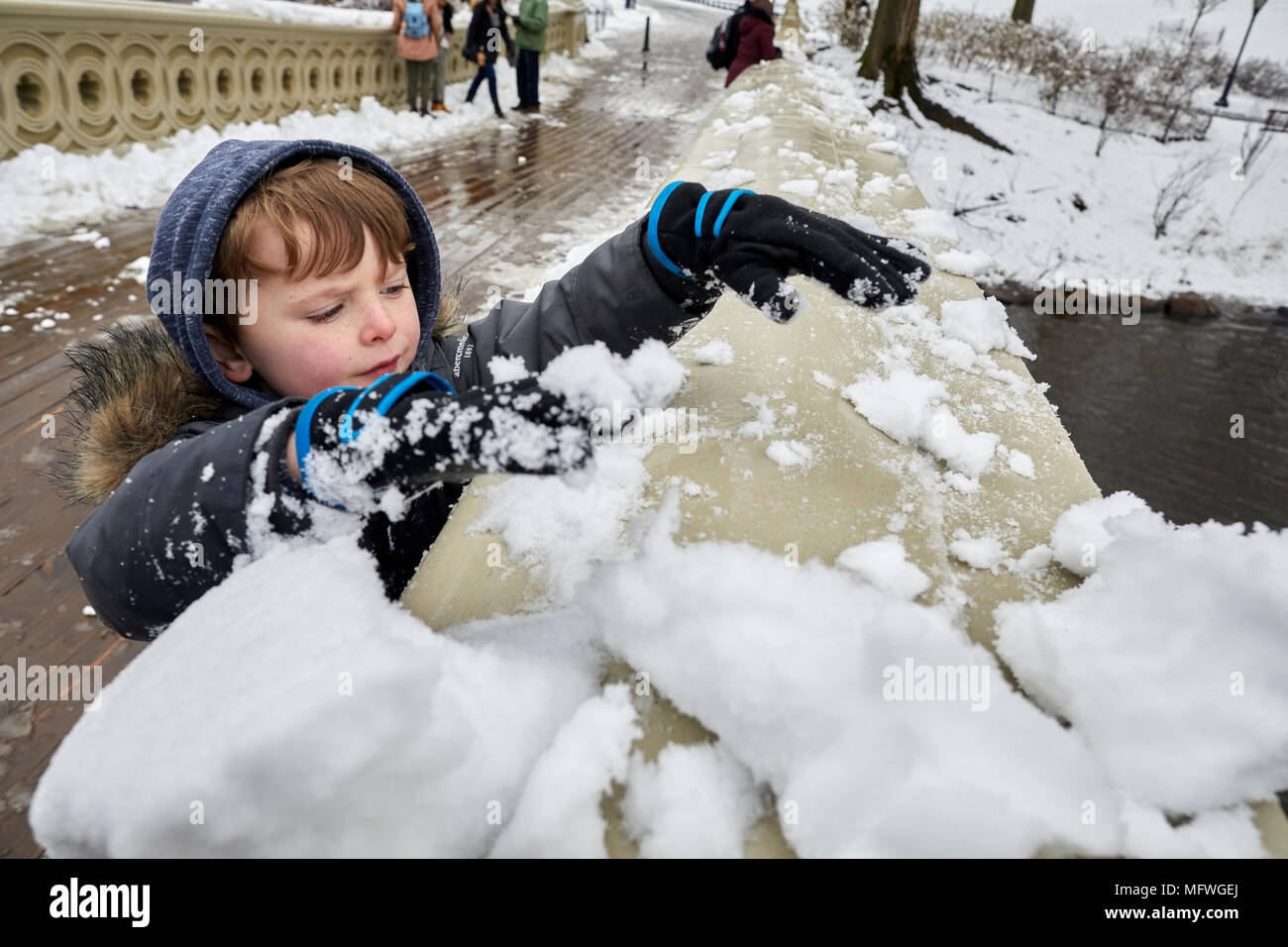 Manhattan in New York City  Easter snow covers Grand Central Park, 1862 pedestrian BOW bridge with a decorative banister is a well-known romantic spot Stock Photo