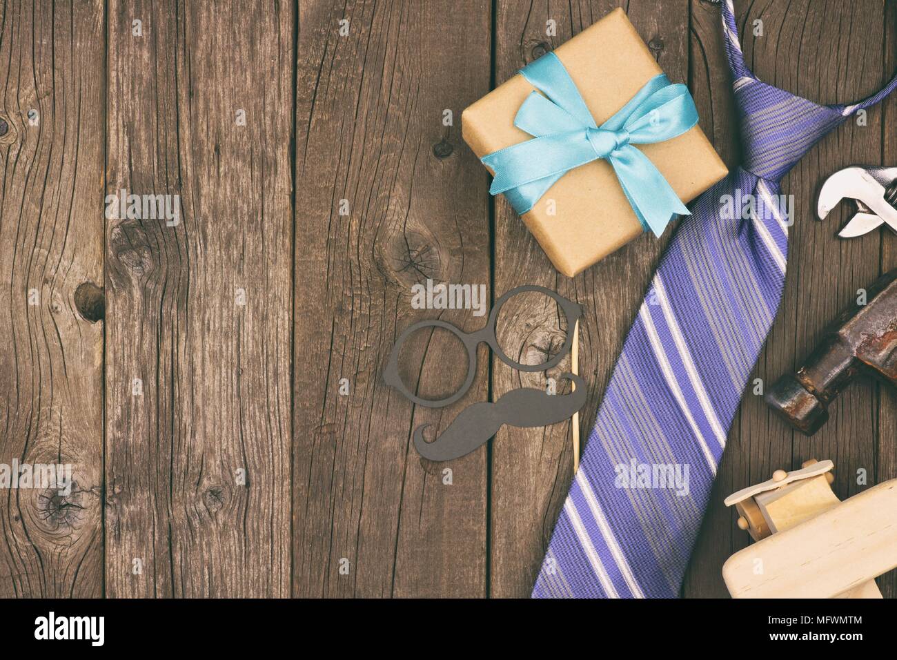 Fathers Day side border of gifts, tie and decor on a rustic wood