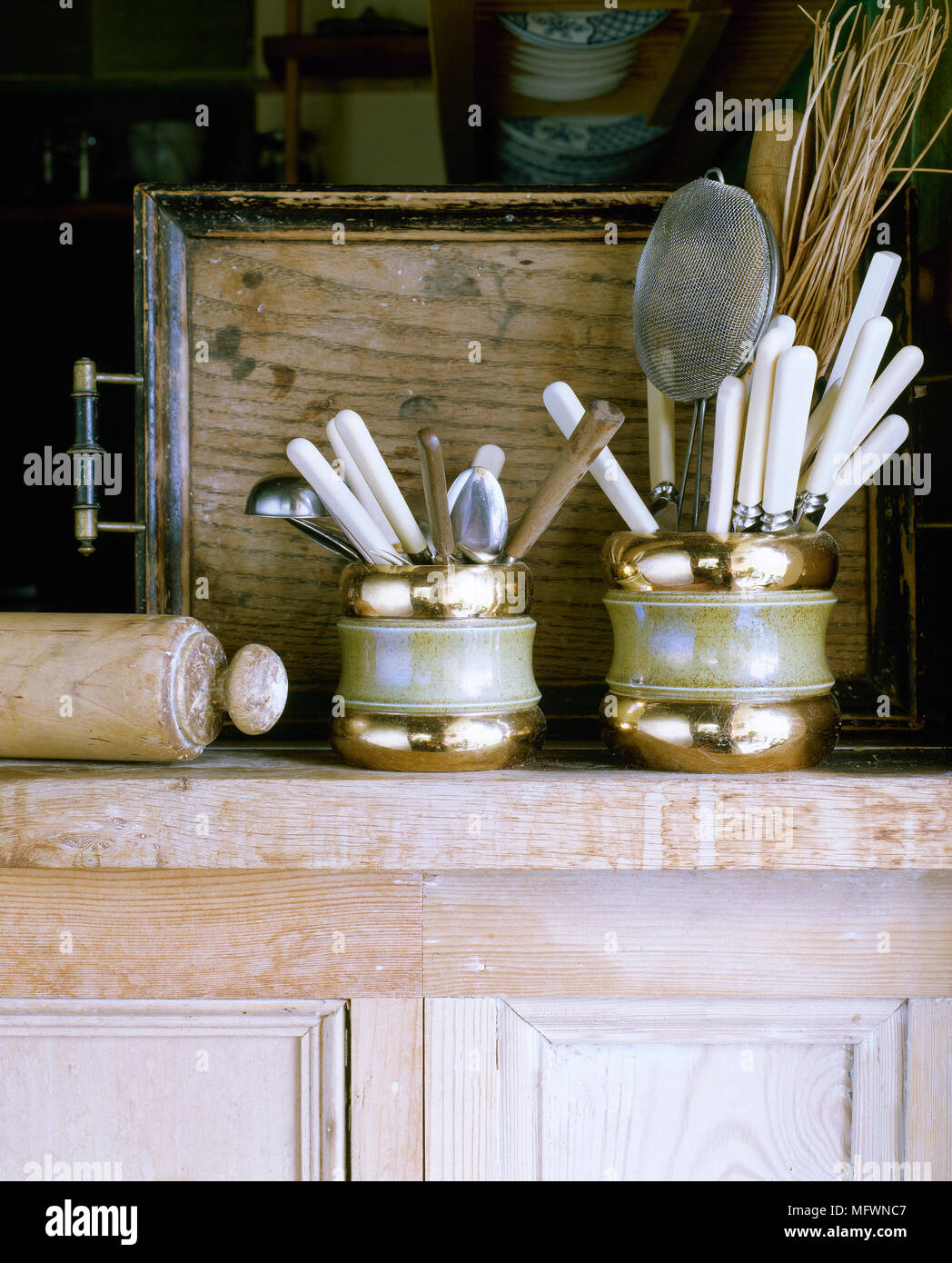 https://c8.alamy.com/comp/MFWNC7/detail-of-a-distressed-wood-cabinet-topped-with-kitchen-utensils-in-antique-containers-MFWNC7.jpg