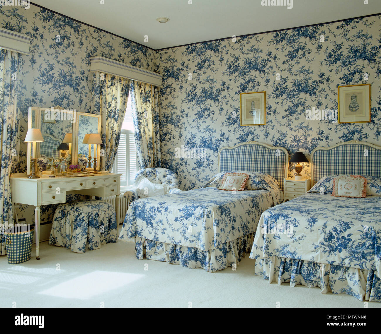 Single beds with blue and white toile de Jouy bed linen and coordinating curtains Stock Photo
