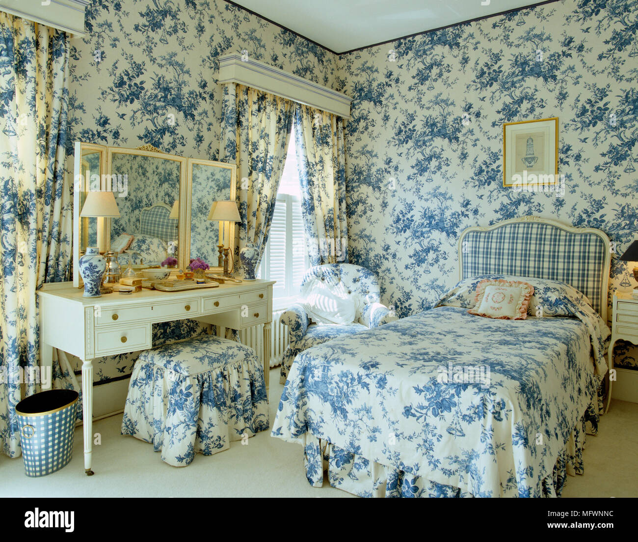 Single bed with blue and white toile de Jouy bed linen and coordinating curtains Stock Photo