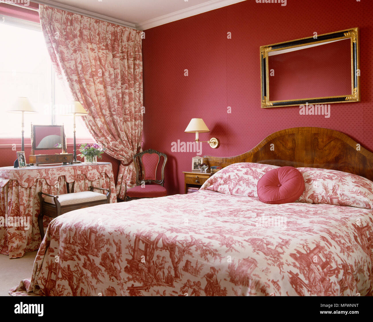 Double bed with pink and white toile de Jouy bed linen and coordinating curtains Stock Photo