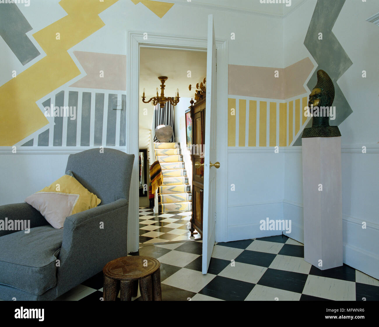 Grey armchair next to open door with view to hallway Stock Photo Alamy