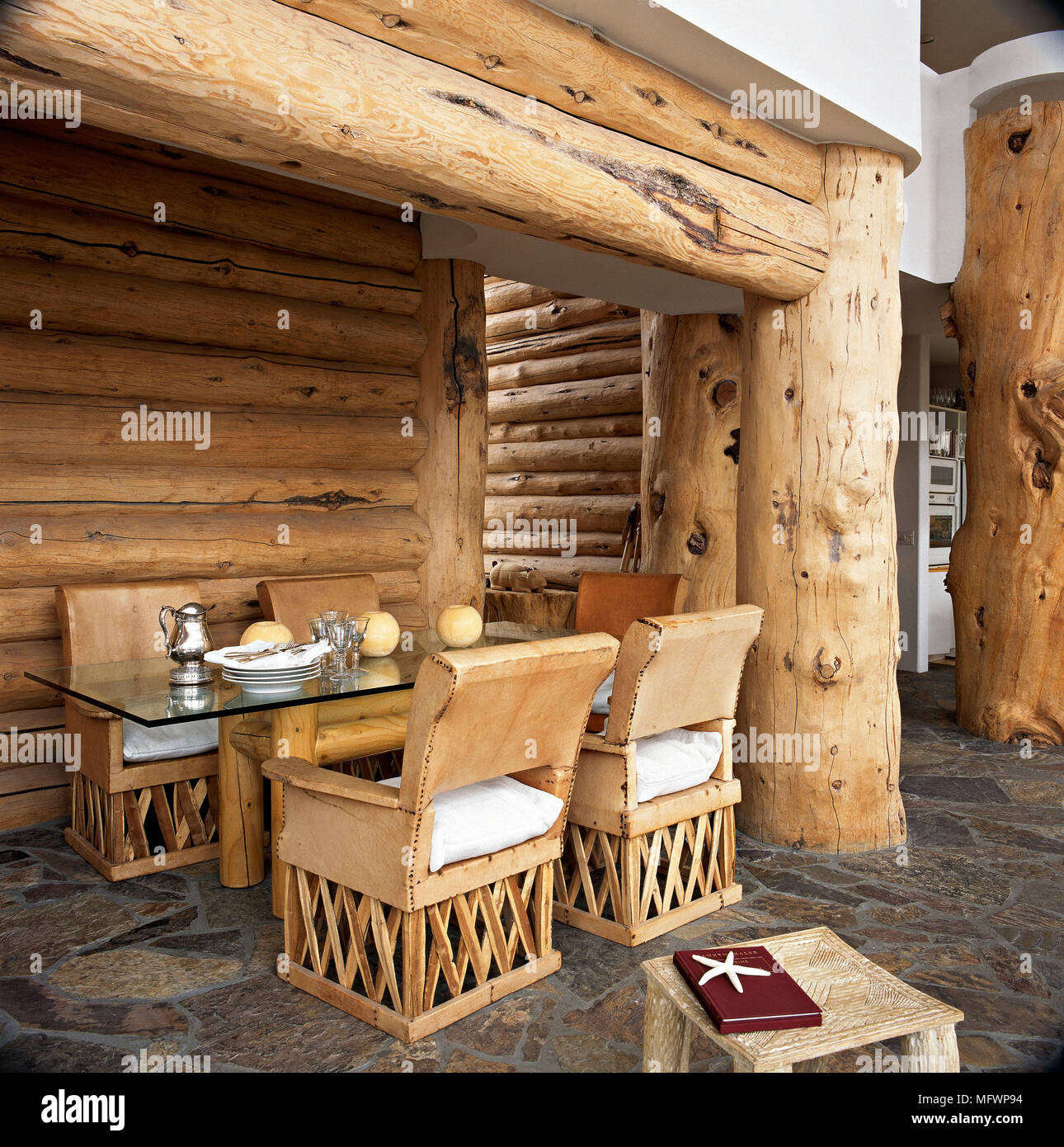 Dining room with timber log walls and stone floor. Stock Photo