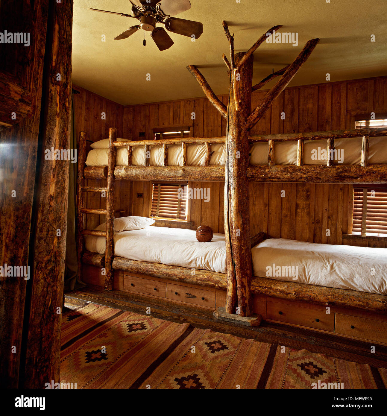 Bedroom with timber bunk beds and wooden panelling on wall. Stock Photo