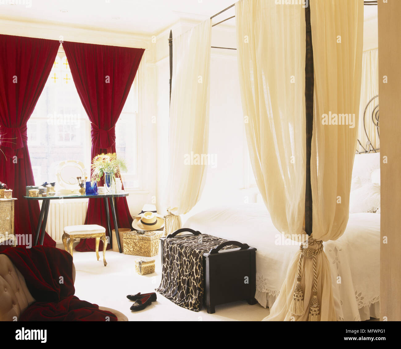 Clothes Draped Over Trunk At Bottom Of Four Poster Bed With Drapes