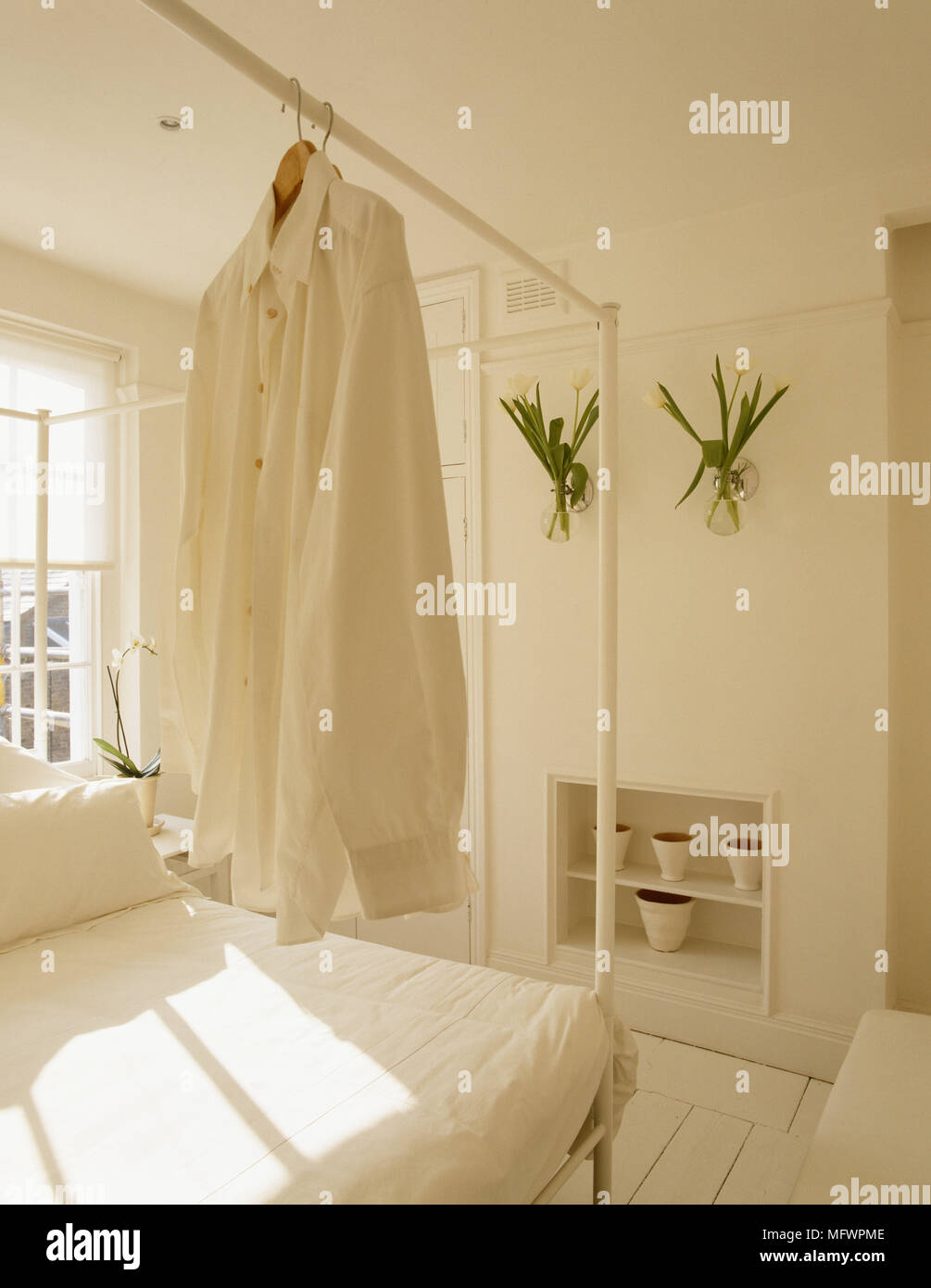 Shirt Hanging From Rail Of Four Poster Bed In Neutral Colour