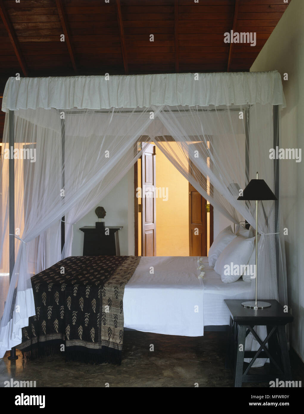 White four poster double bed with blanket in front of doorway Stock Photo Alamy