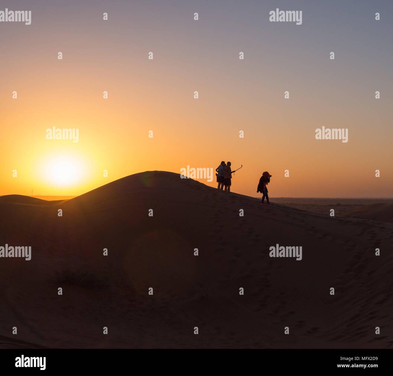Tourists in Safari desert taking selfie and  enjoying sunset view near Dubai, UAE Stock Photo