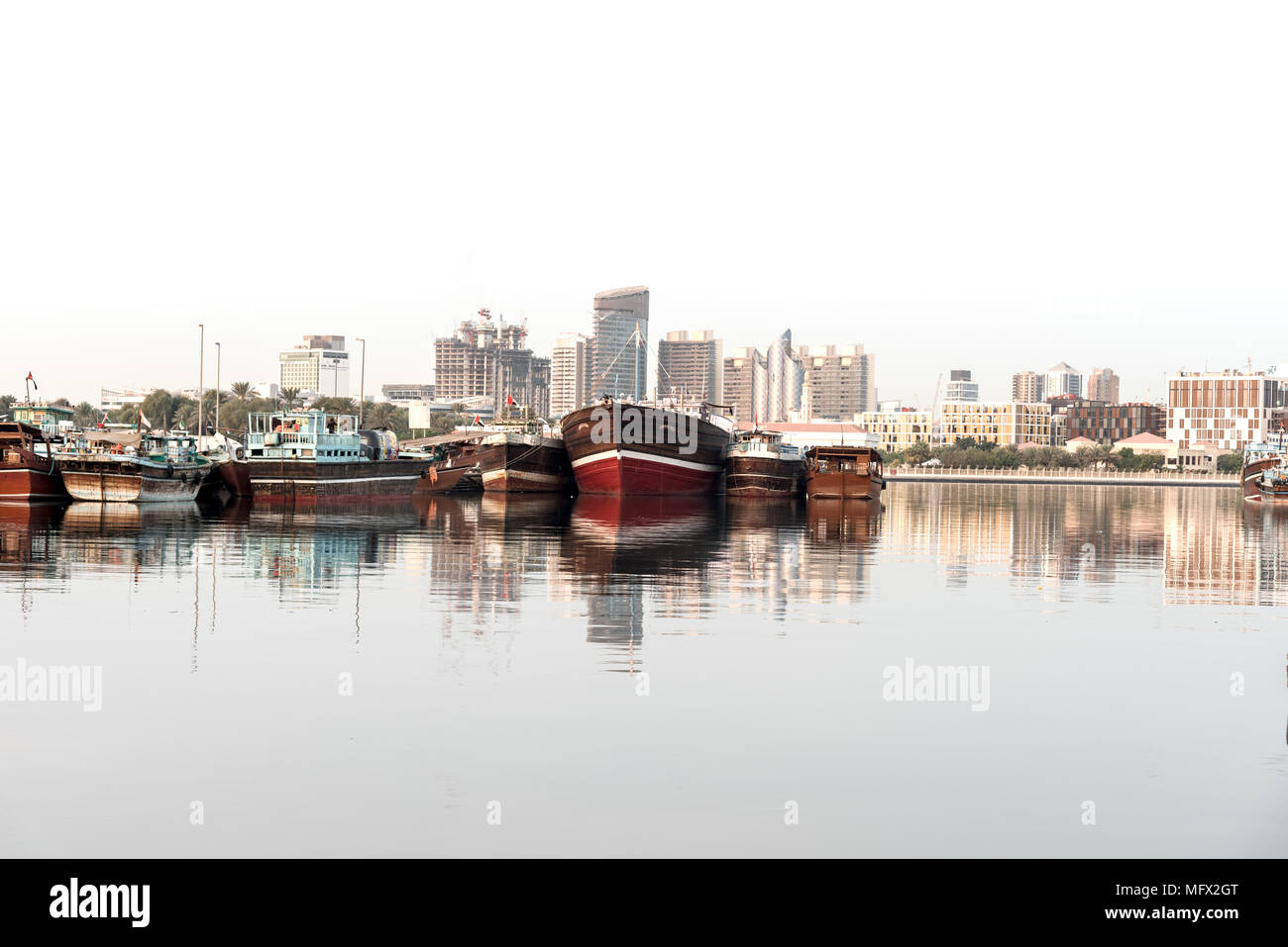 Wooden boats docked in front of the Dubai city skyline. Stock Photo