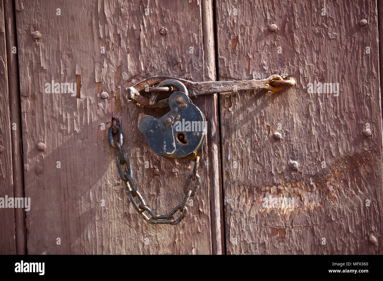 Antique Lock And Chain On An Early American Barn Door In Colonial