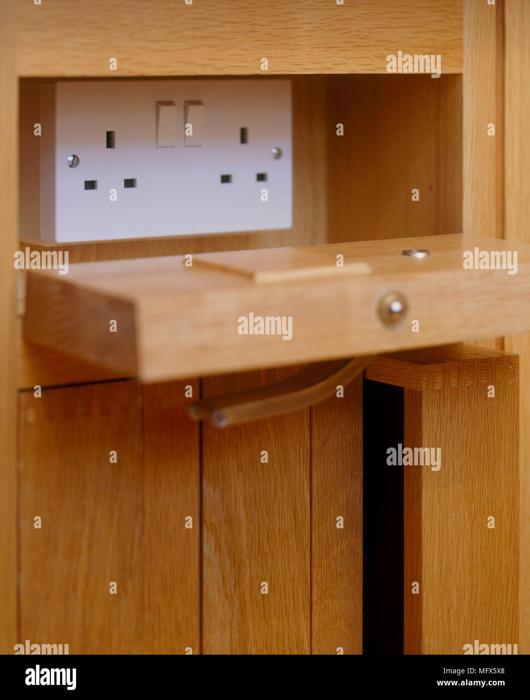 A detail of a concealed electric socket, set in wooden panel, Stock Photo