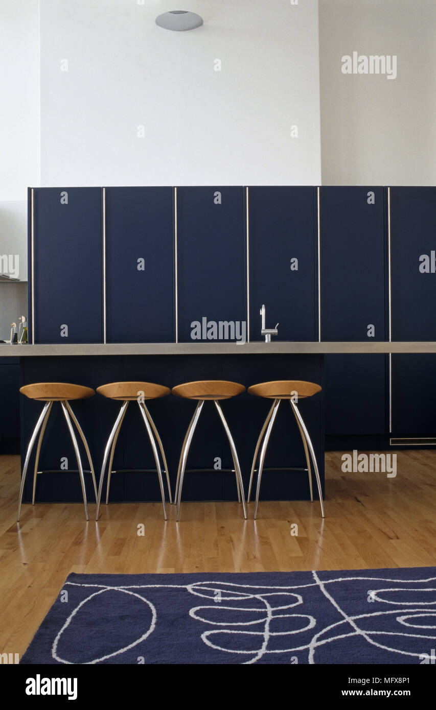 Bar stools facing kitchen breakfast bar Stock Photo - Alamy