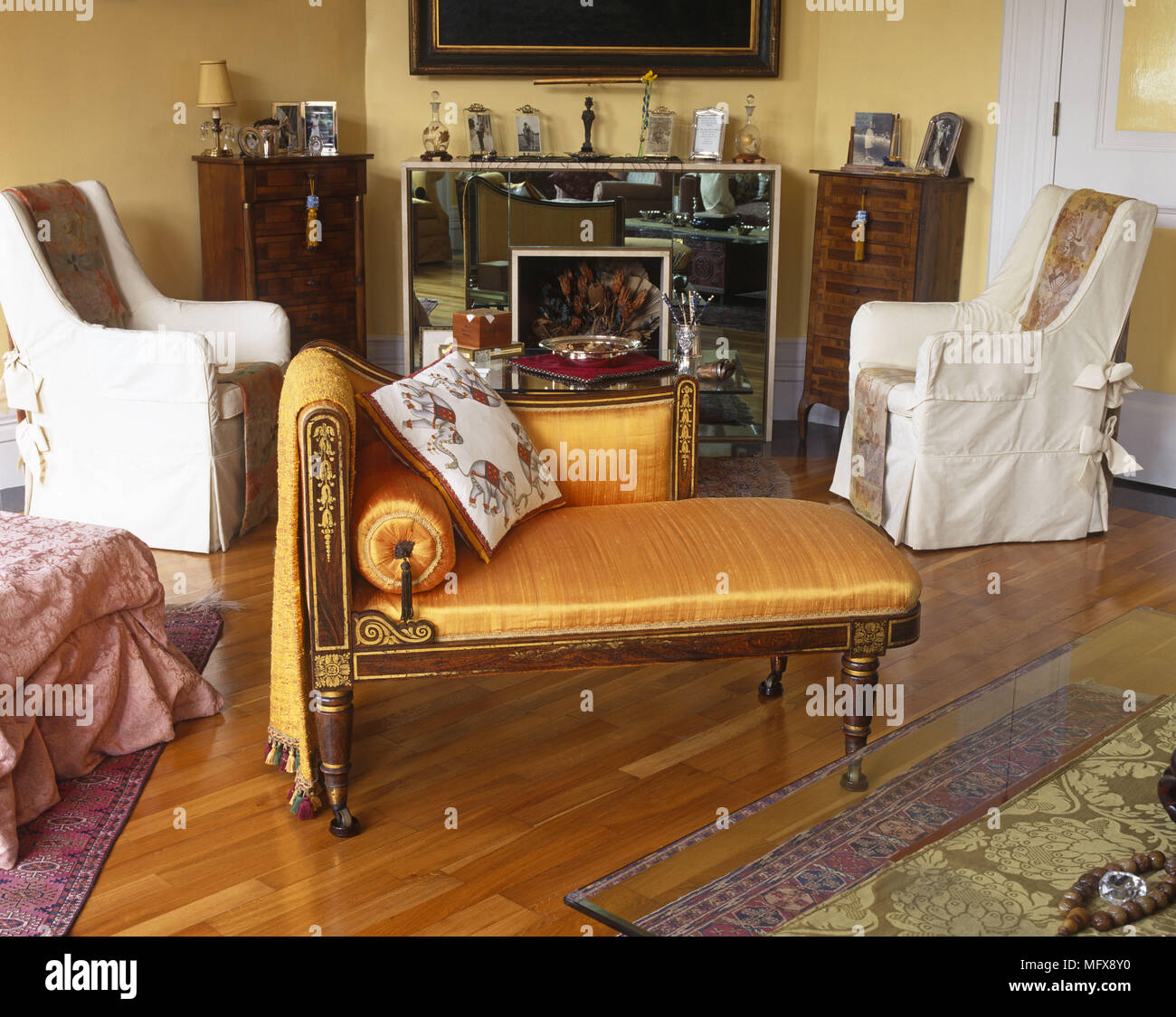 Period style upholstered chaise longue in front of fireplace in yellow