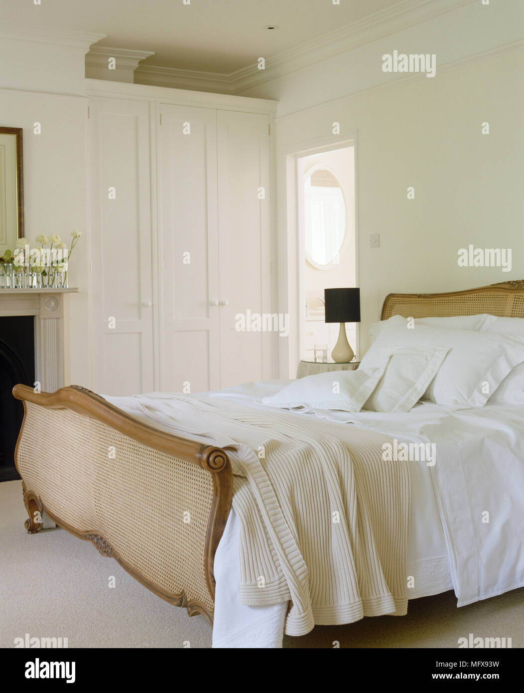 Period Style Wooden Double Bed Next To Built In Wardrobes Stock