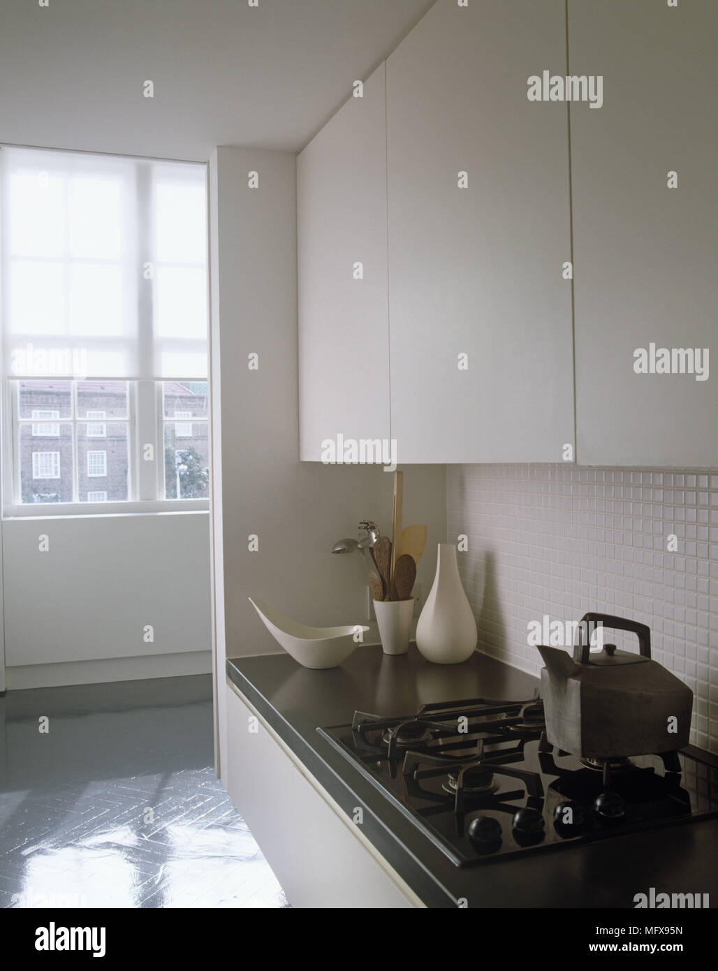 Gas hob set in worktop with white fitted kitchen units above Stock