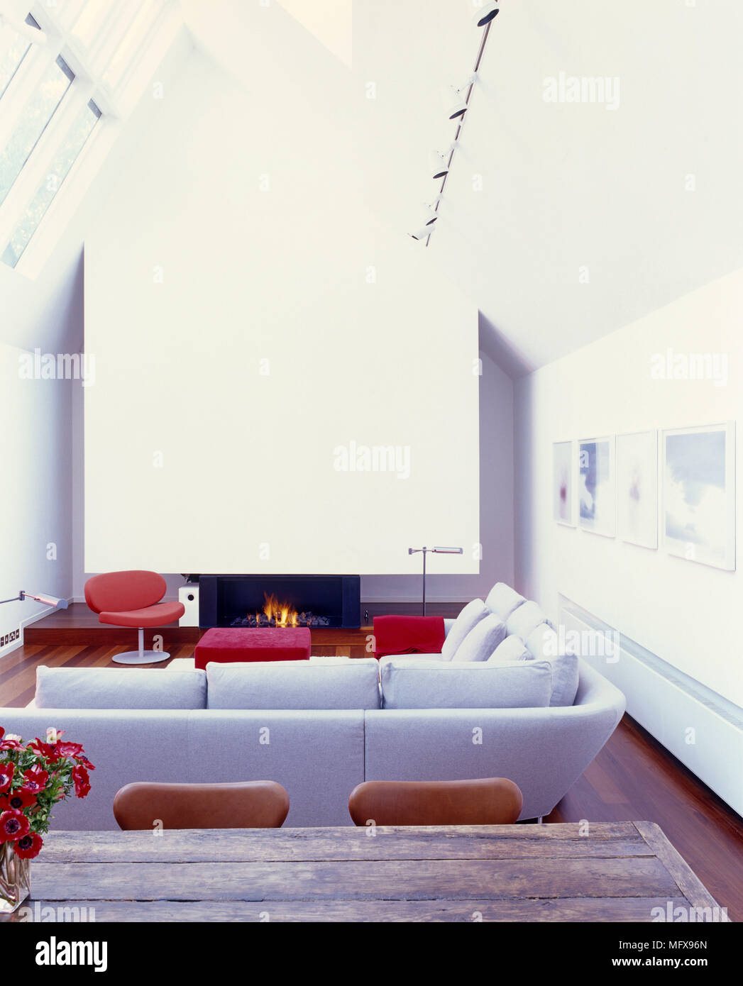 Upholstered sofa facing fireplace with lit fire in white sitting room