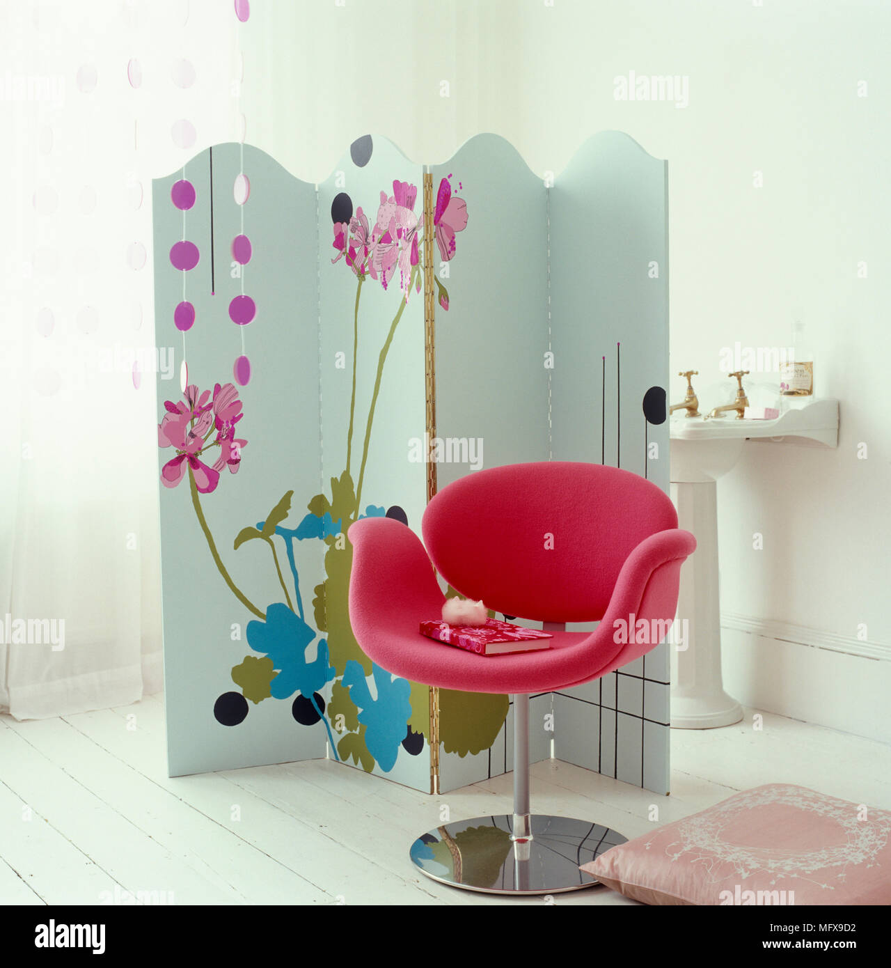 Modern pink chair in front of folding screen in bathroom Stock Photo