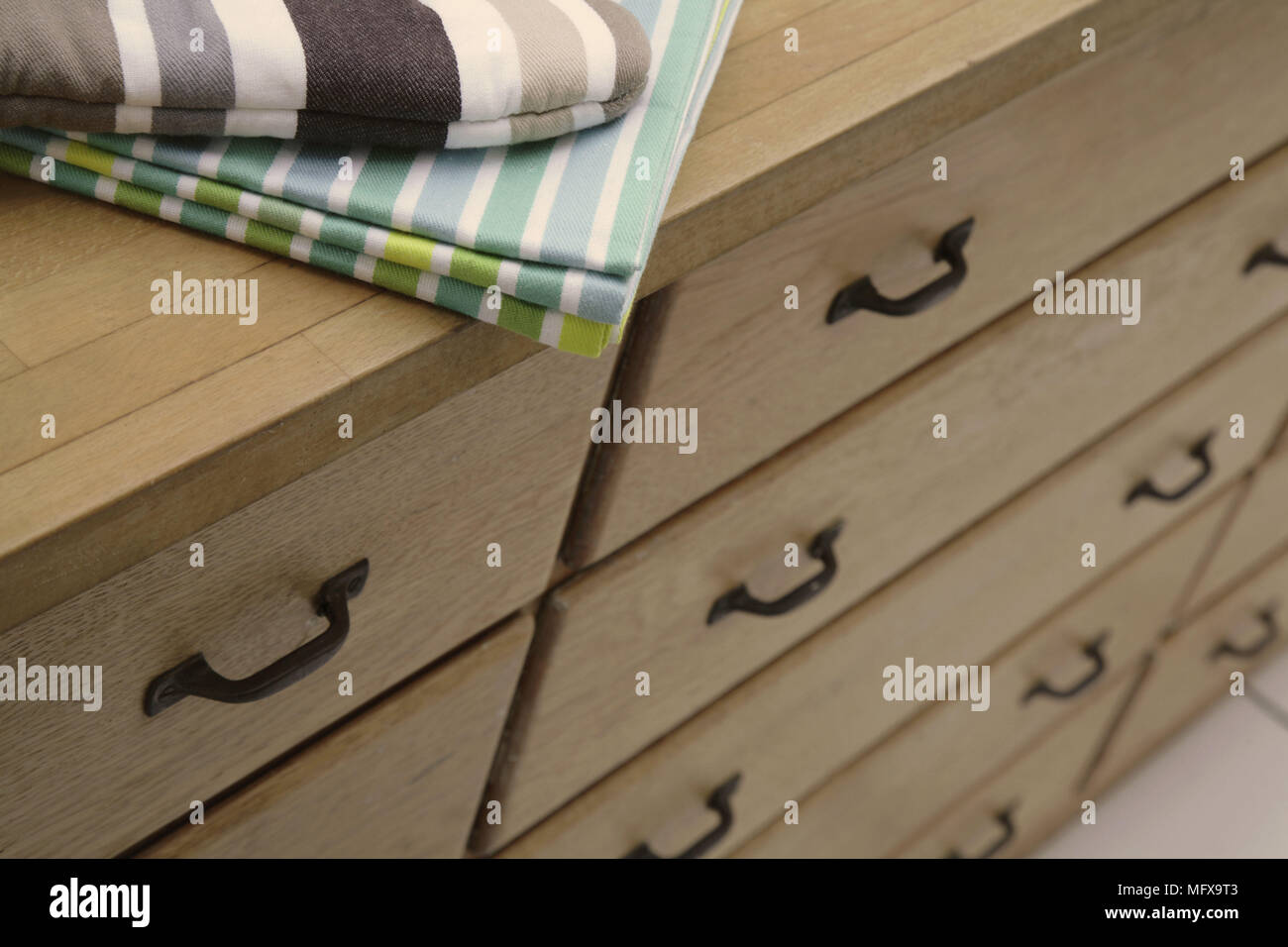 Tea towel on wooden chest of drawers. Stock Photo