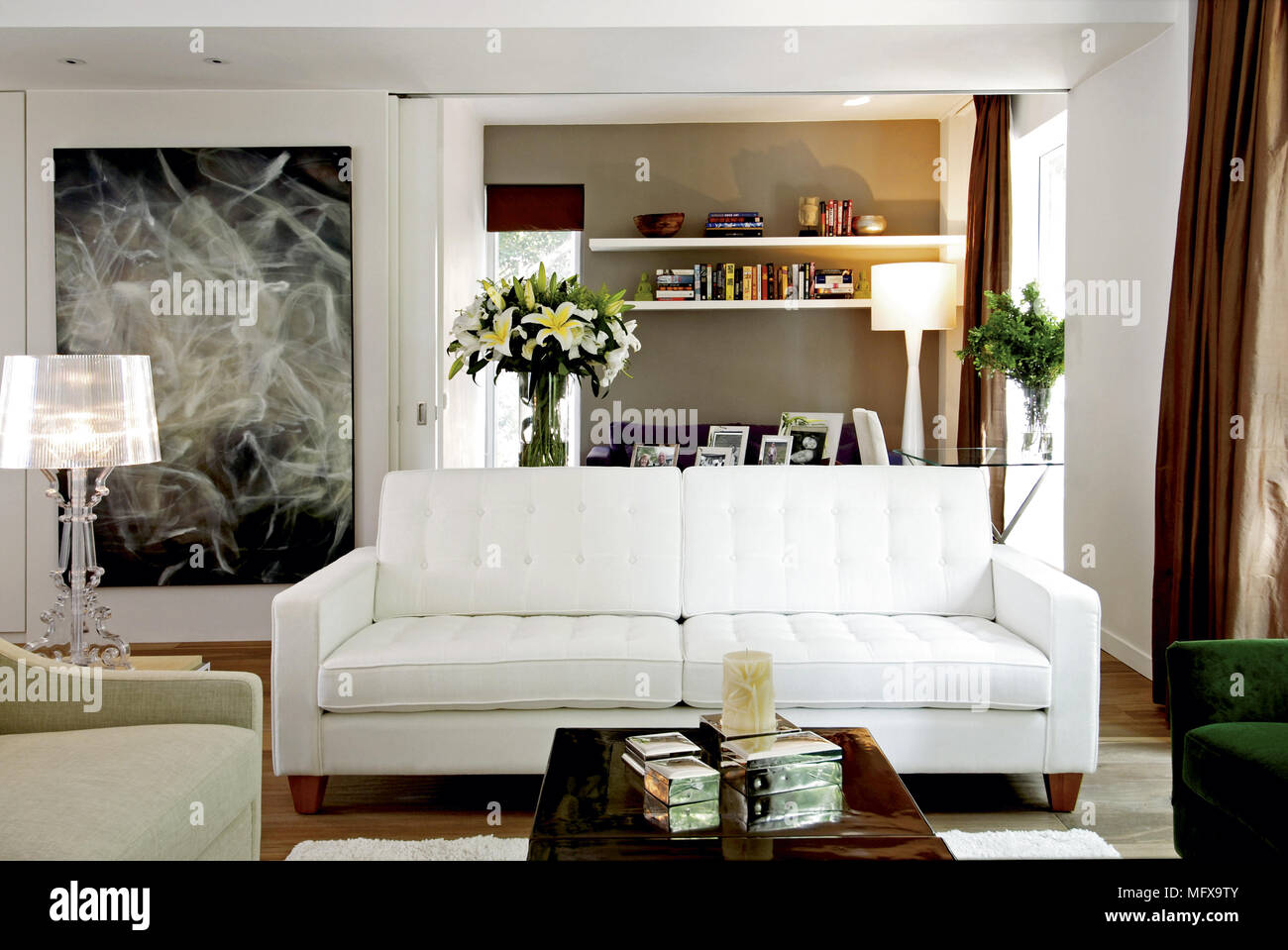 Coffee table in front of white sofa in modern sitting room Stock Photo