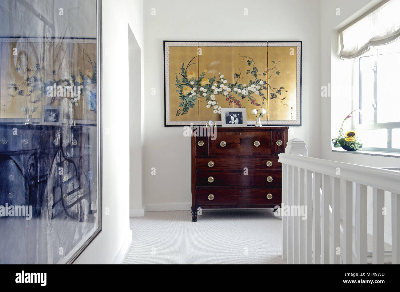 Artwork above chest of drawers in white hallway Stock Photo