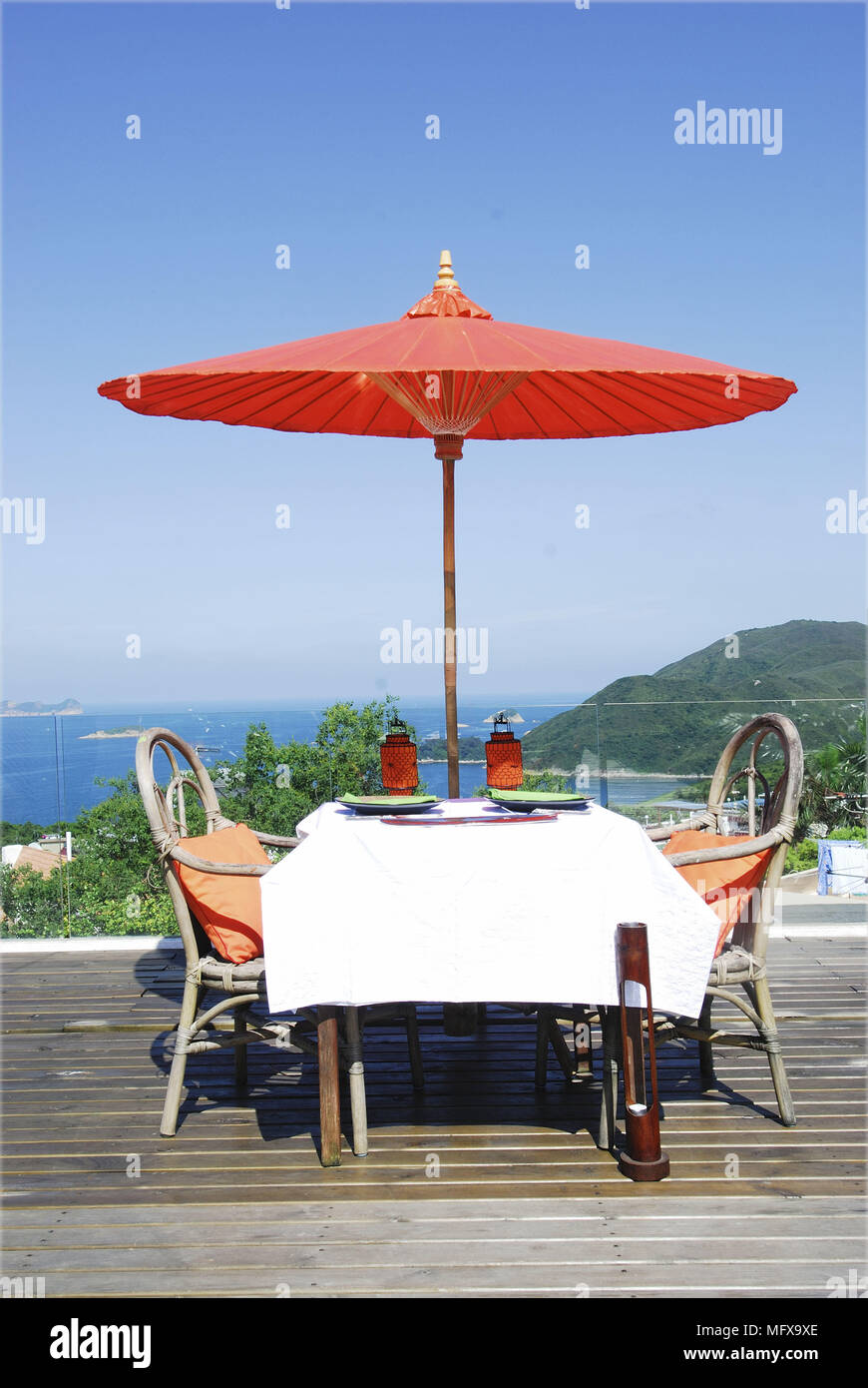 Table for two on decked terrace overlooking ocean view Stock Photo