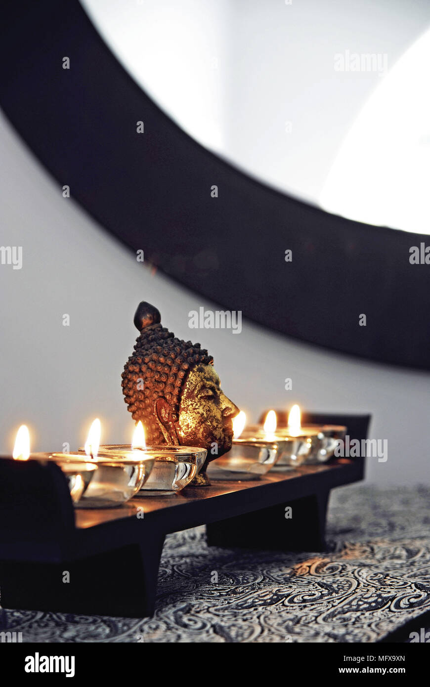 Bhudda head and lit candles Stock Photo