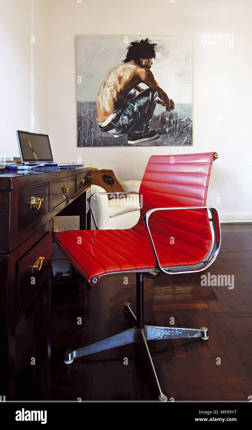 Red Eames chair at desk in modern home office Stock Photo