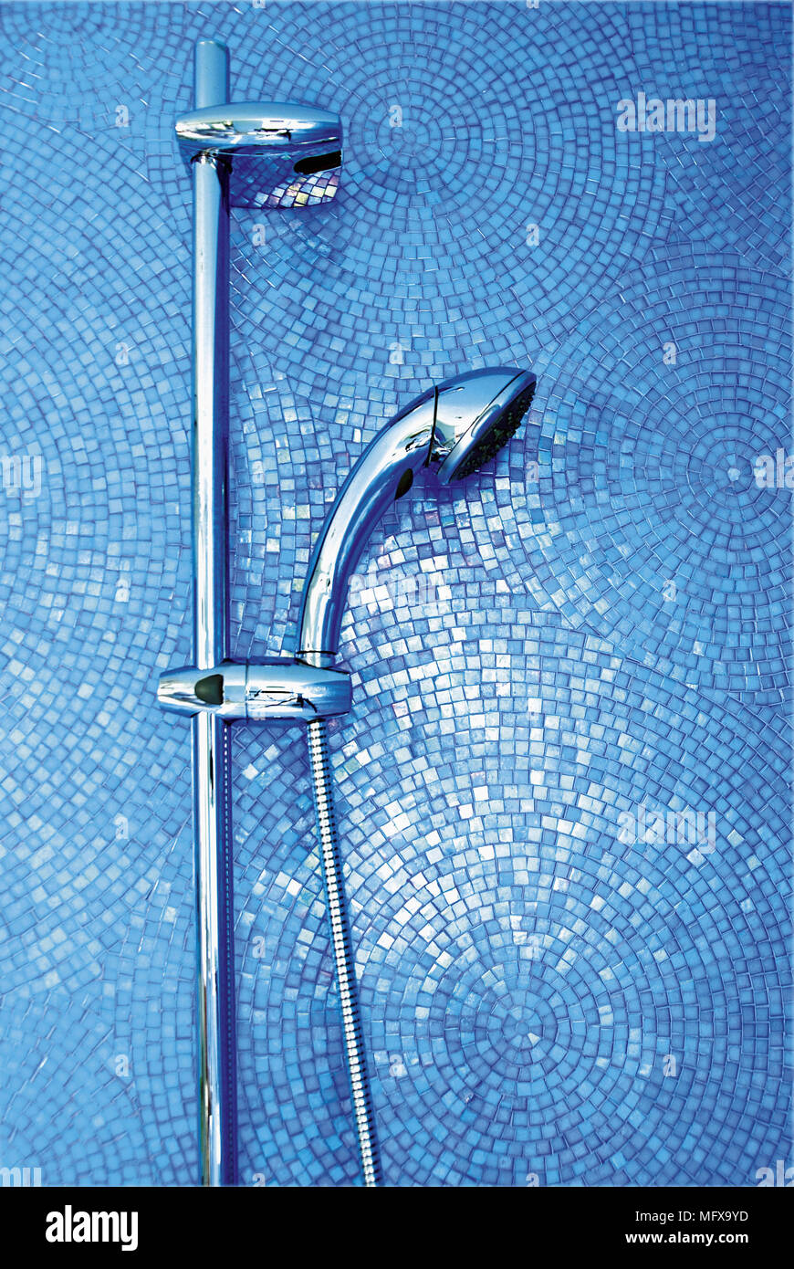 Chrome shower head against blue tiled wall Stock Photo