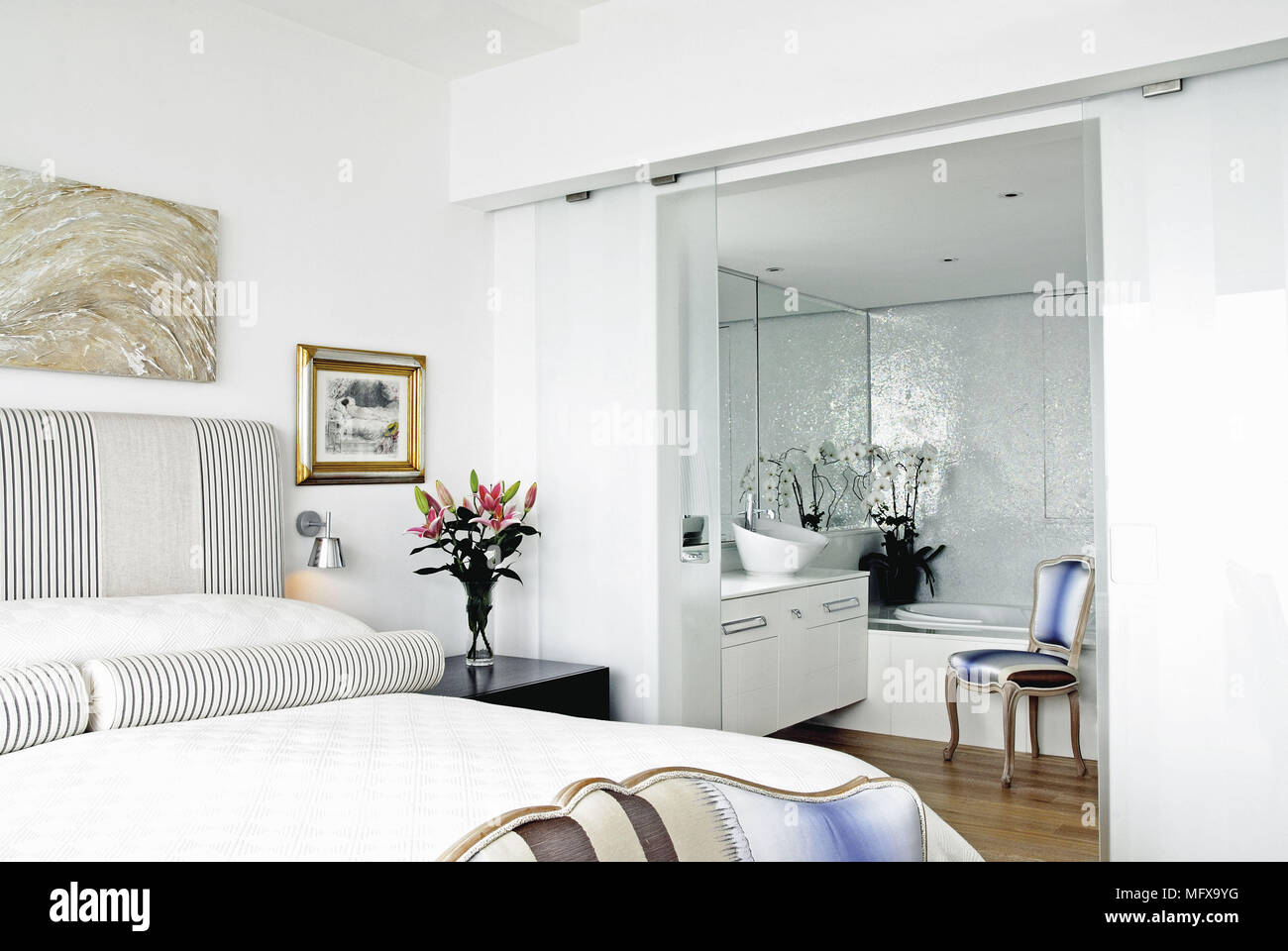 Double bed in traditional style bedroom with ensuite bathroom Stock Photo
