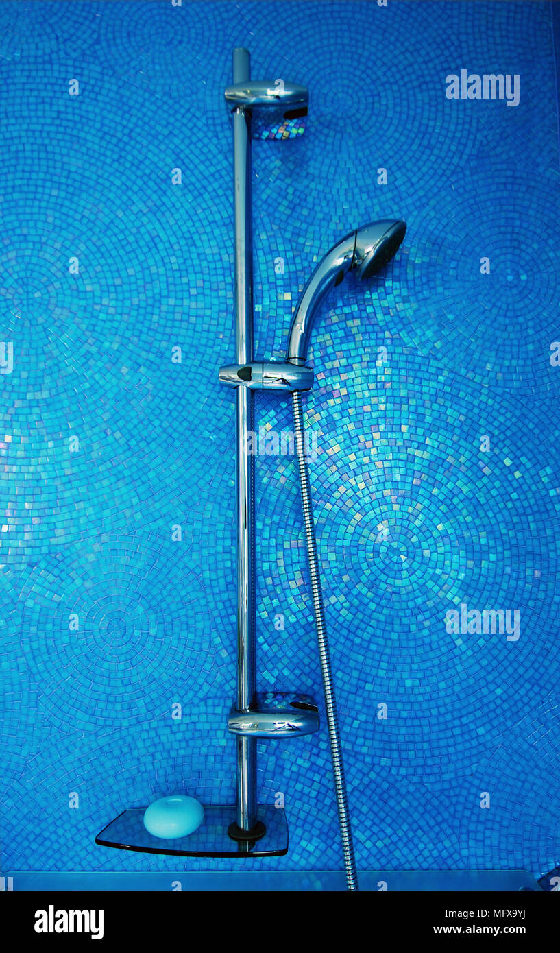 Chrome shower head against blue tiled wall Stock Photo