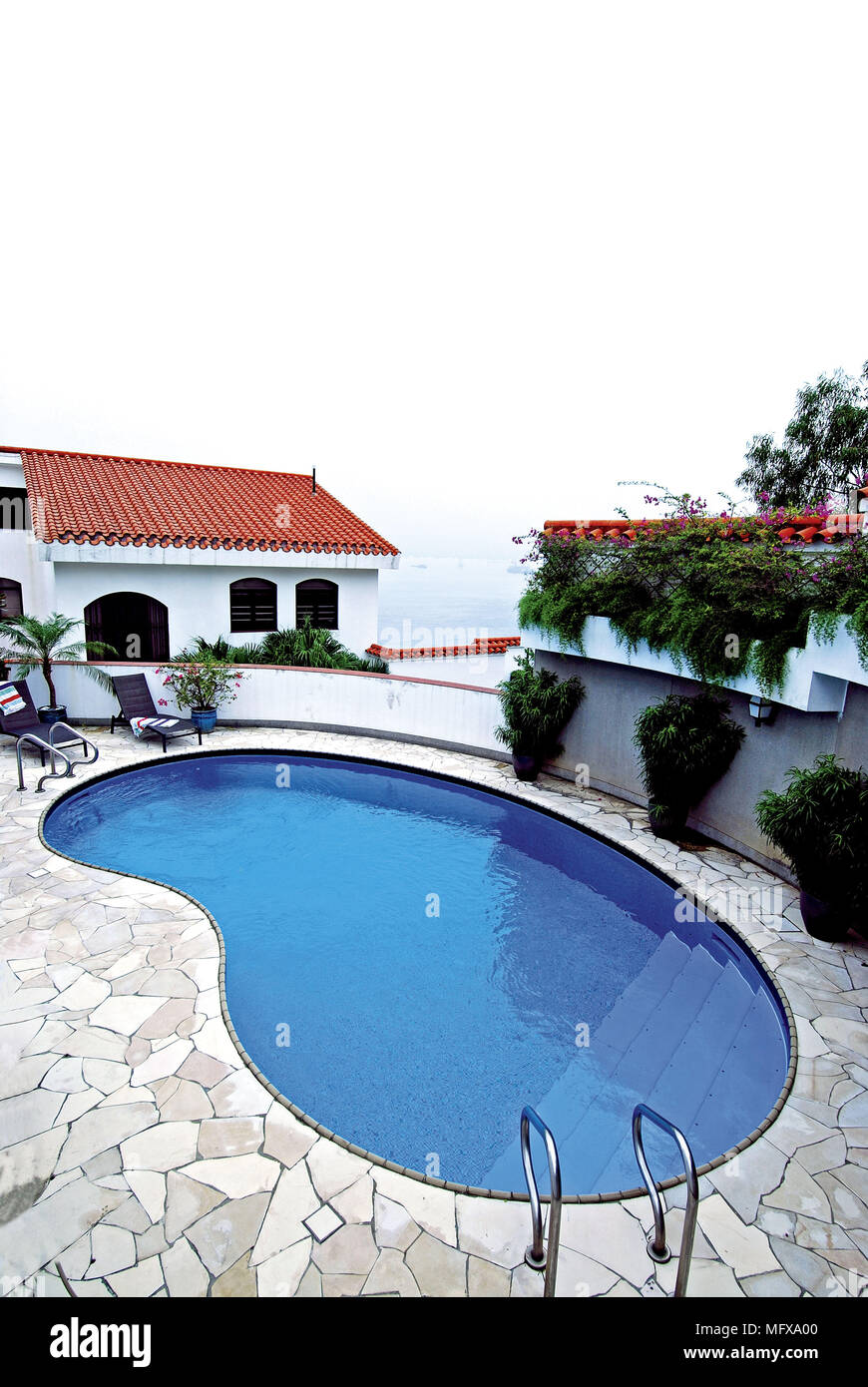 Exterior of modern villa with kidney shaped swimming pool Stock Photo
