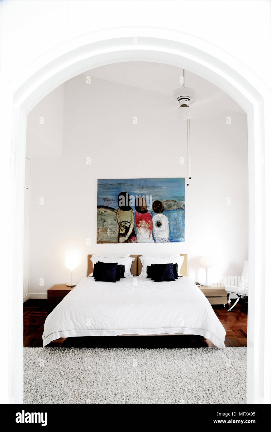 View through archway to double bed in modern bedroom Stock Photo